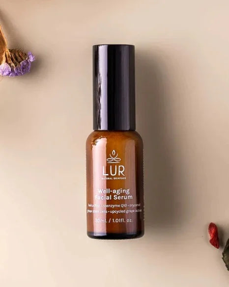 LUR well-aging gezichtsserum in bruine fles op beige achtergrond met gedroogde bloemen, anti-aging huidverzorging.
