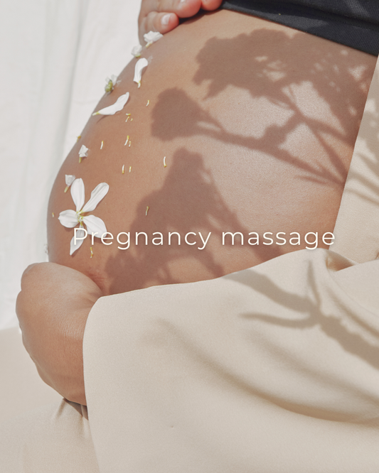 Zwangerschapsbuik met witte bloemen en de tekst 'zwangerschapsmassage', thema ontspanning en welzijn