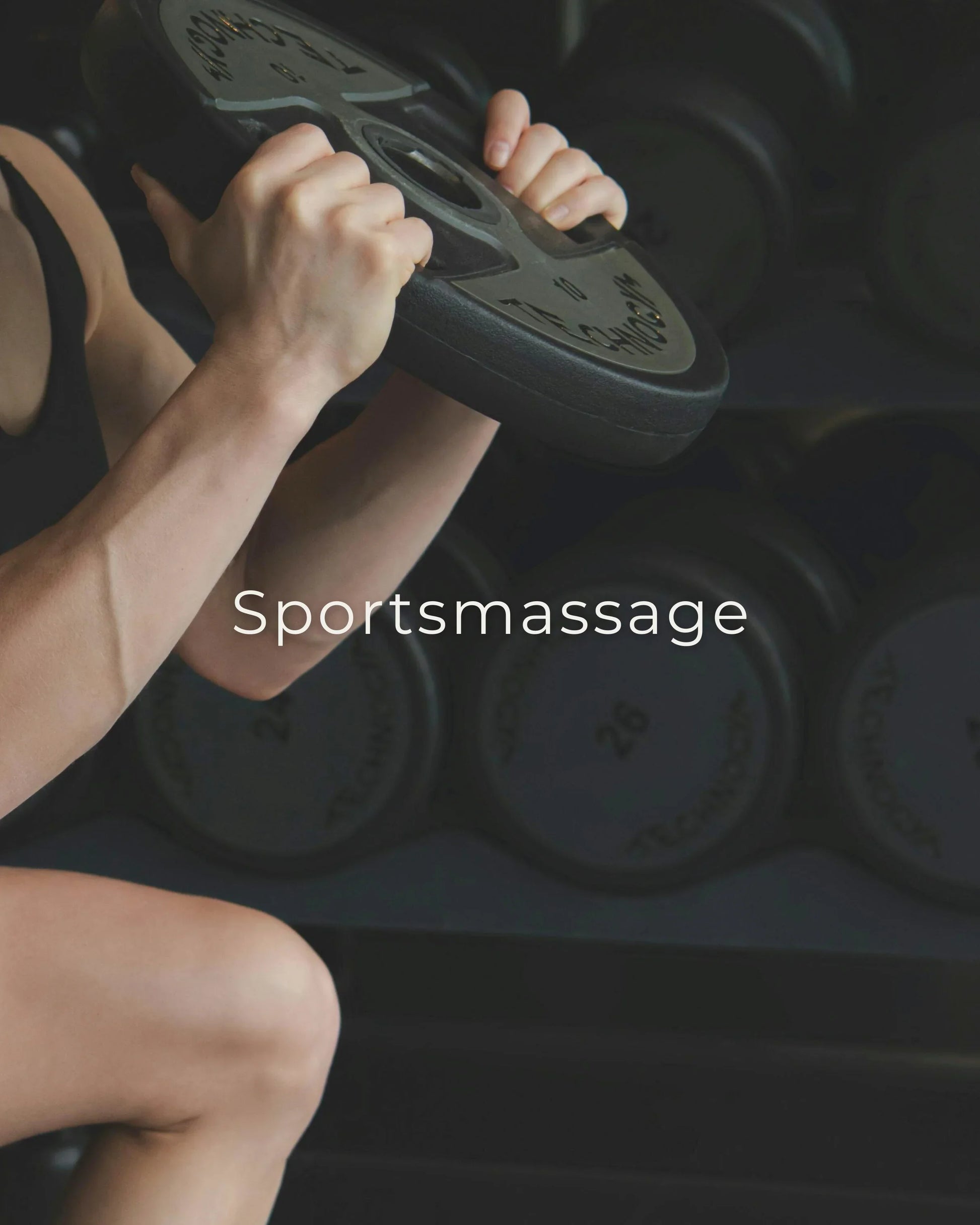 Een atleet pakt een gewichtsschijf vast in de sportschool, waarmee hij sportmassage promoot voor spierherstel en welzijn.