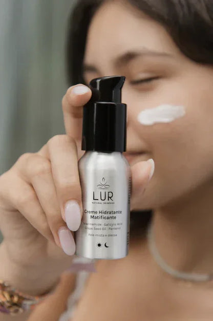 Vrouw brengt matterende gezichtscrème aan terwijl ze LUR hydraterende crème vasthoudt.