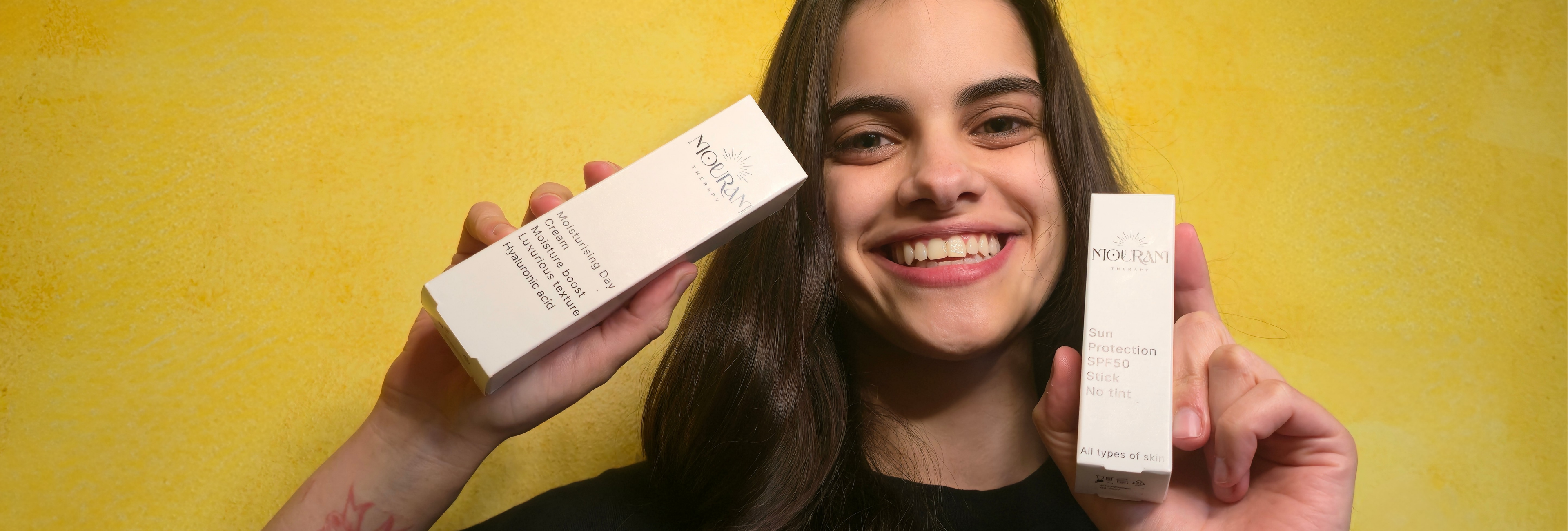 Mouram dagcrème 50ml en zonnebrandcrème SPF 50 in handen